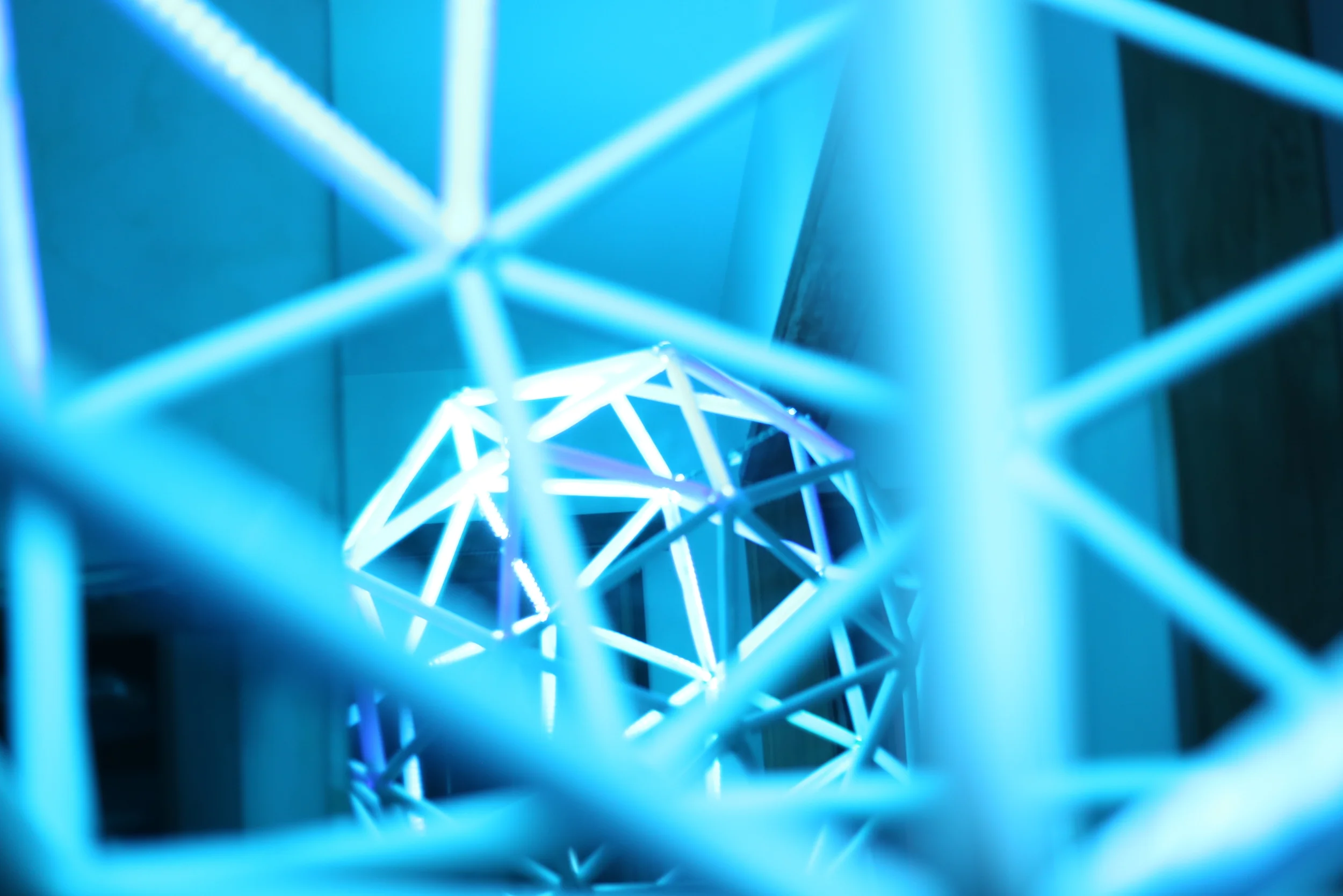 White-blue illuminated polygonal frames within Barcelona’s larger structure.
