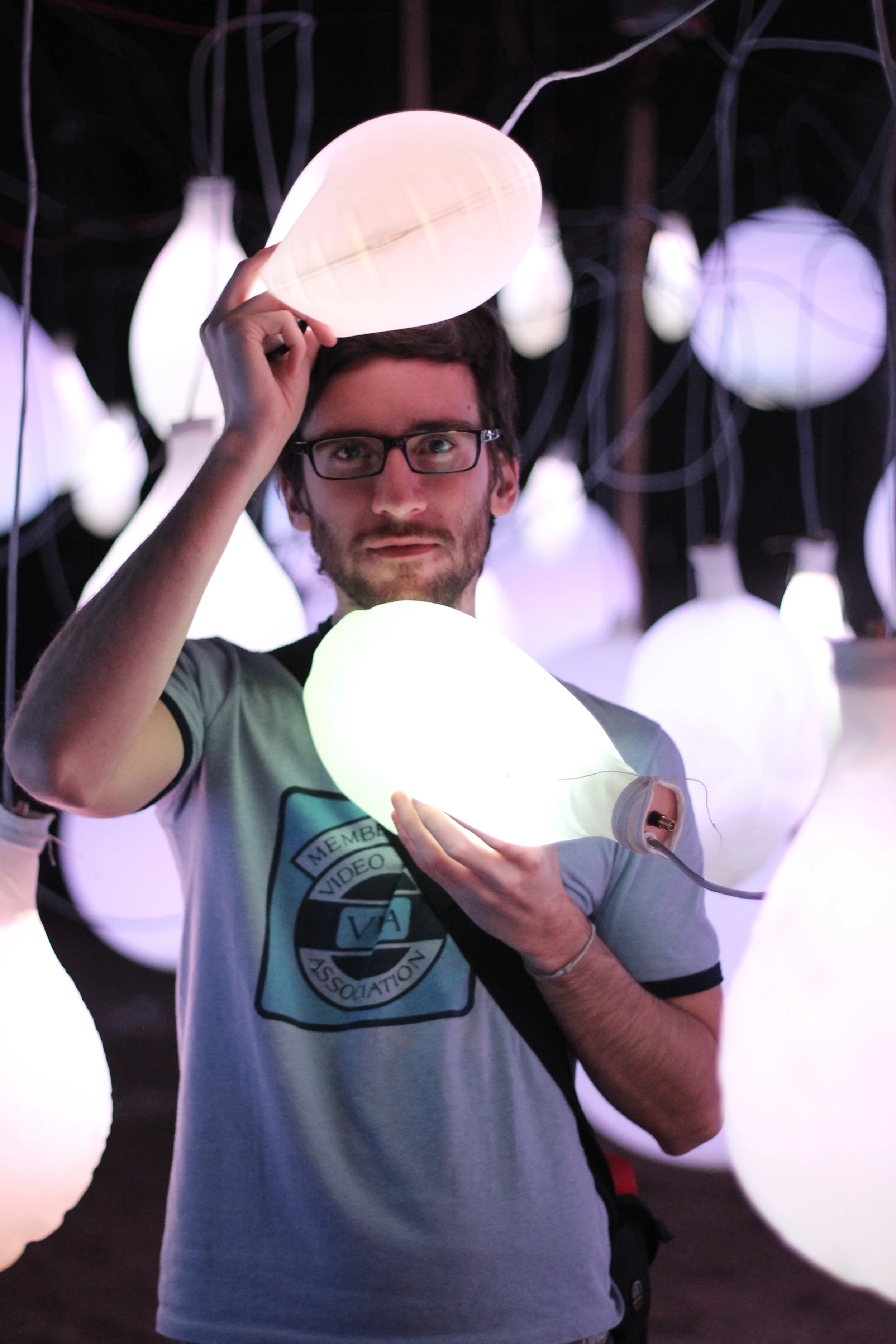 A participant holds illuminated balloons in the Celebra installation.
