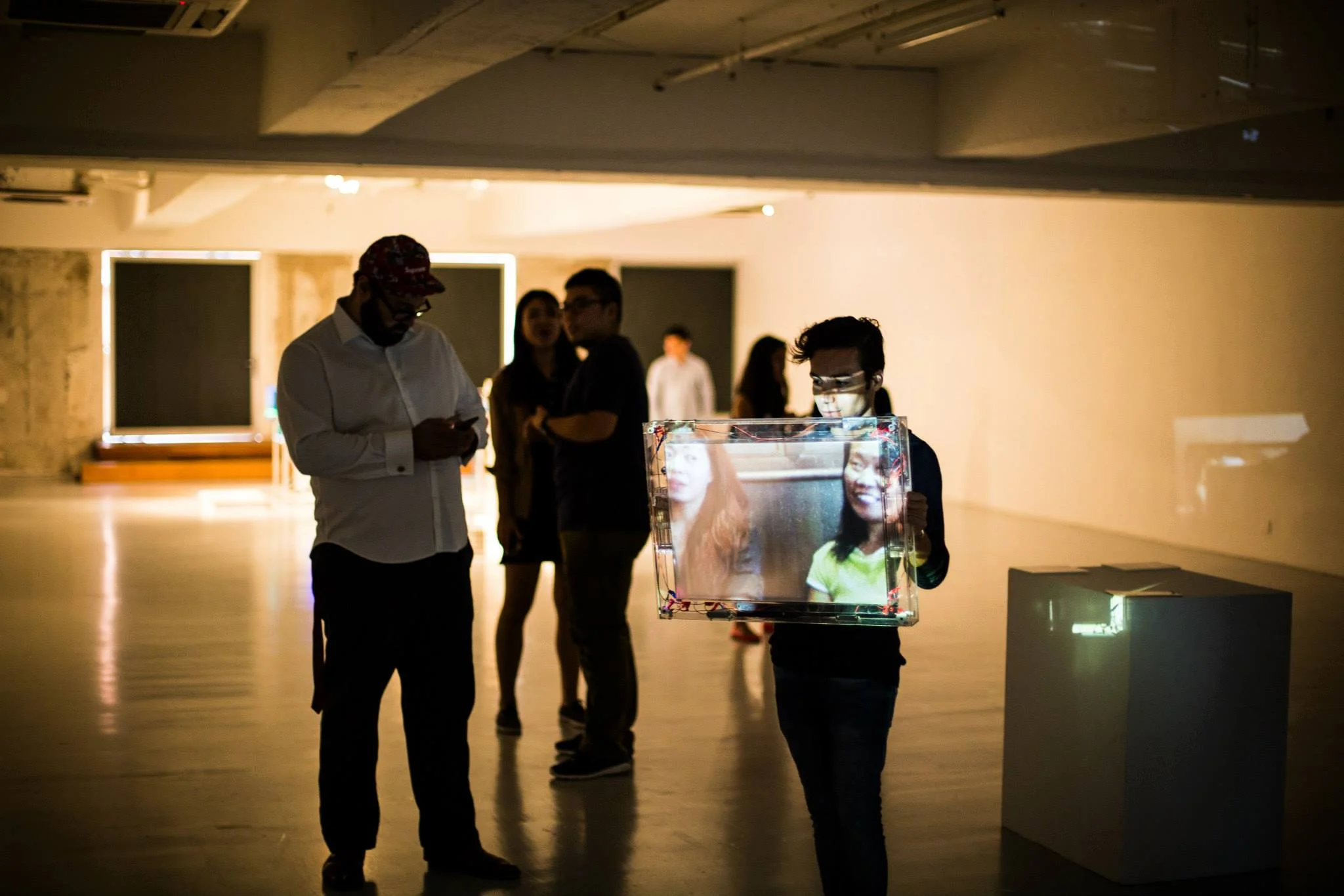 Visitors explore Foreign Helpers using a handheld translucent projection screen.
