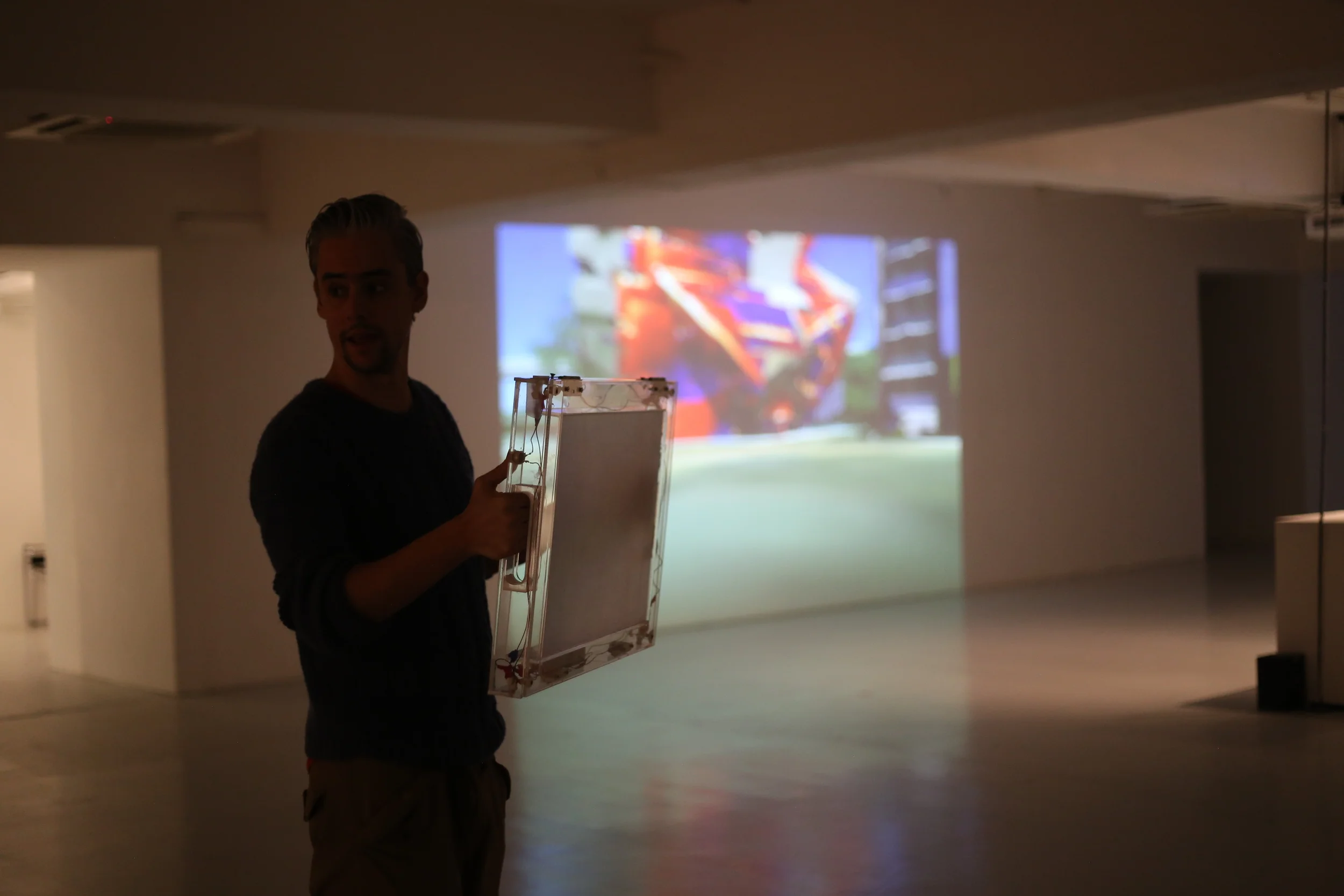 A participant holds a small projection screen in front of a larger projected image.