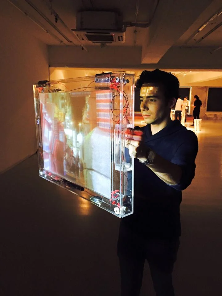 A visitor holding a transparent screen with projected imagery.