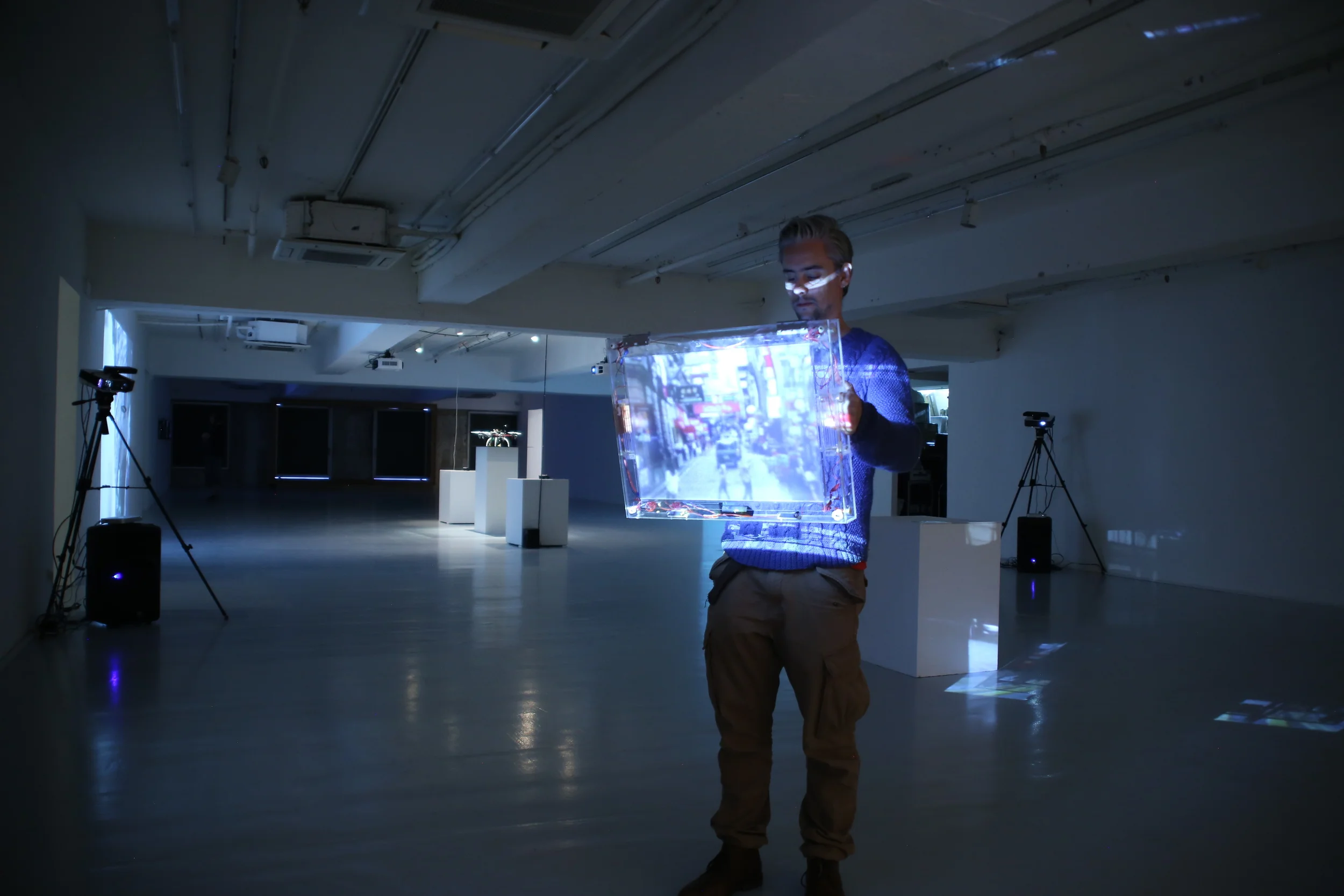 A participant holding a screen illuminated by a blue projection.