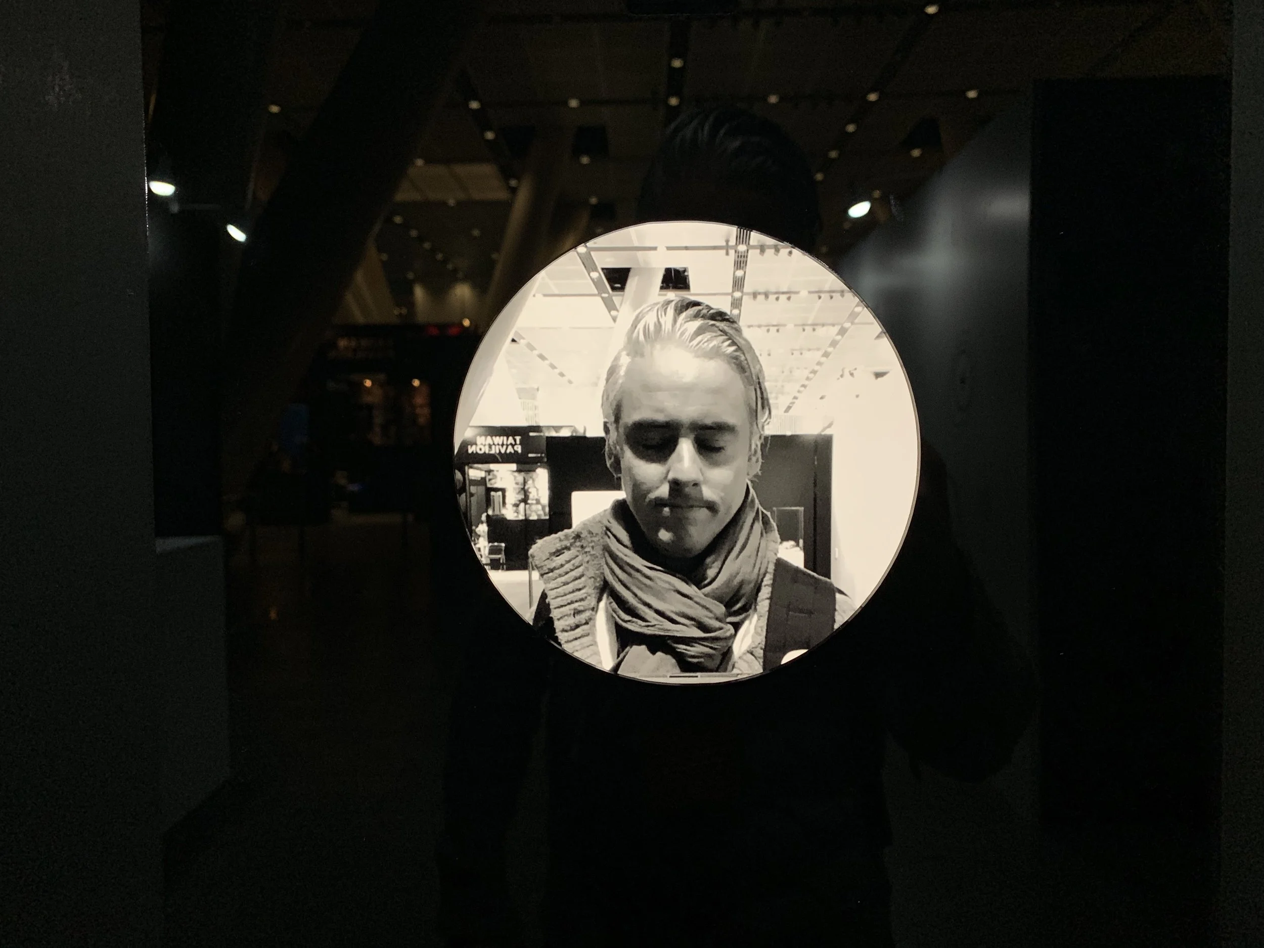 A downturned closed-eye portrait wearing a scarf.