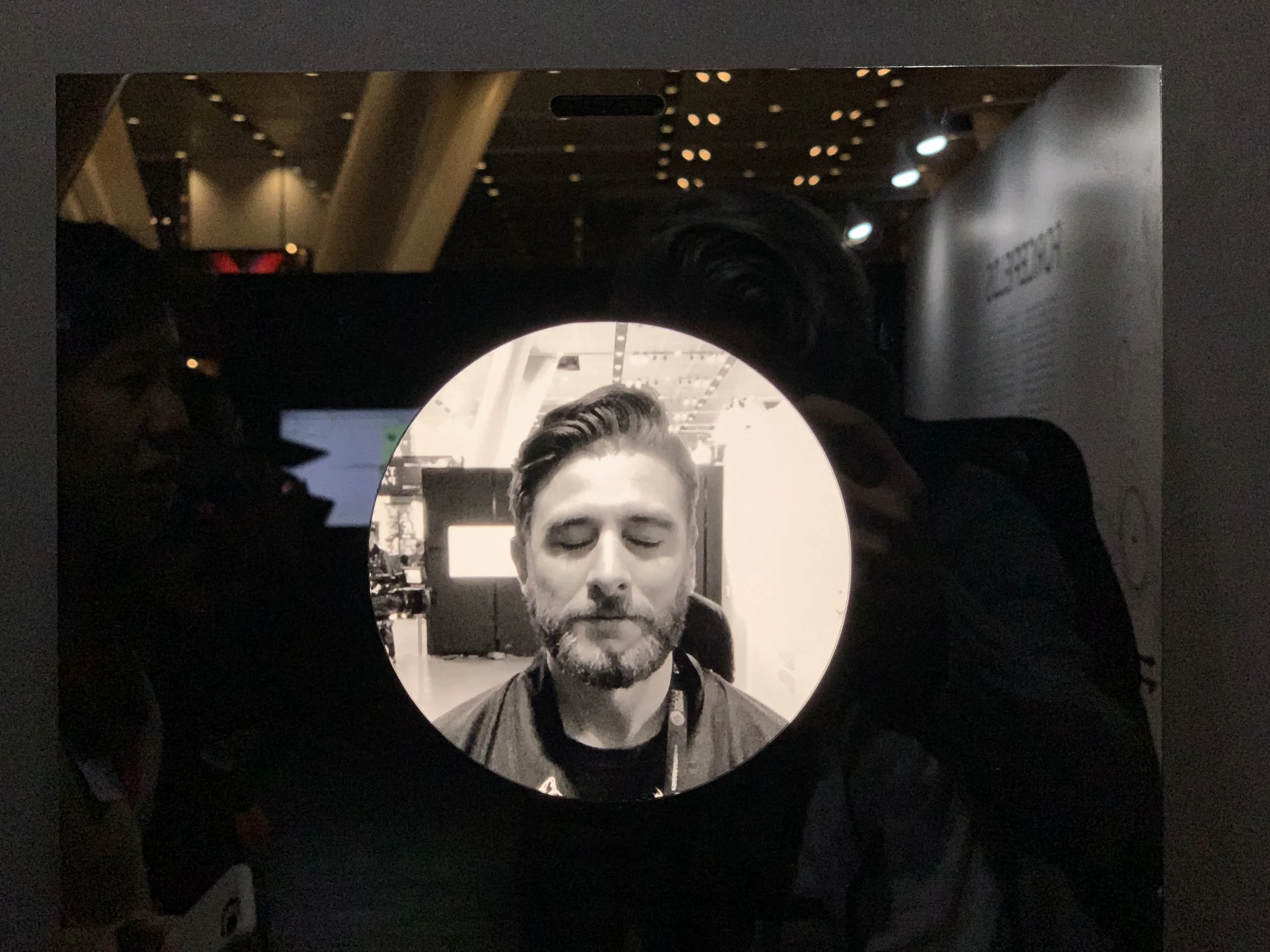 A close-up closed-eye portrait fills the circular display.