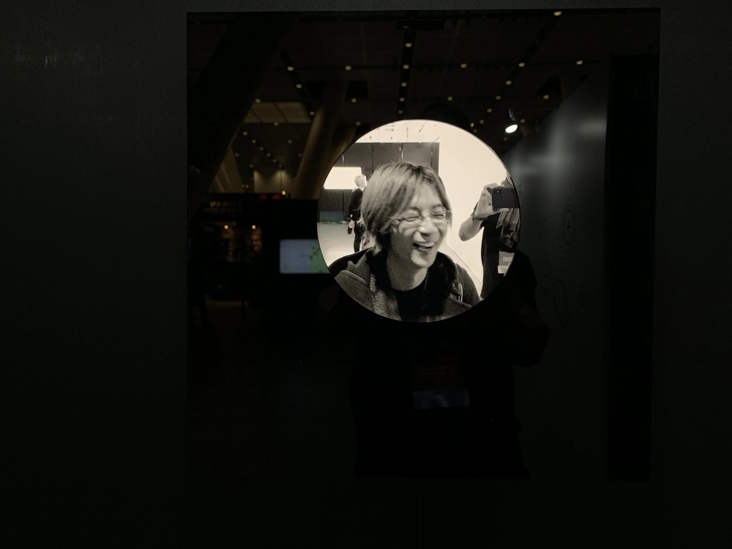 A smiling light-haired portrait in the circular display.