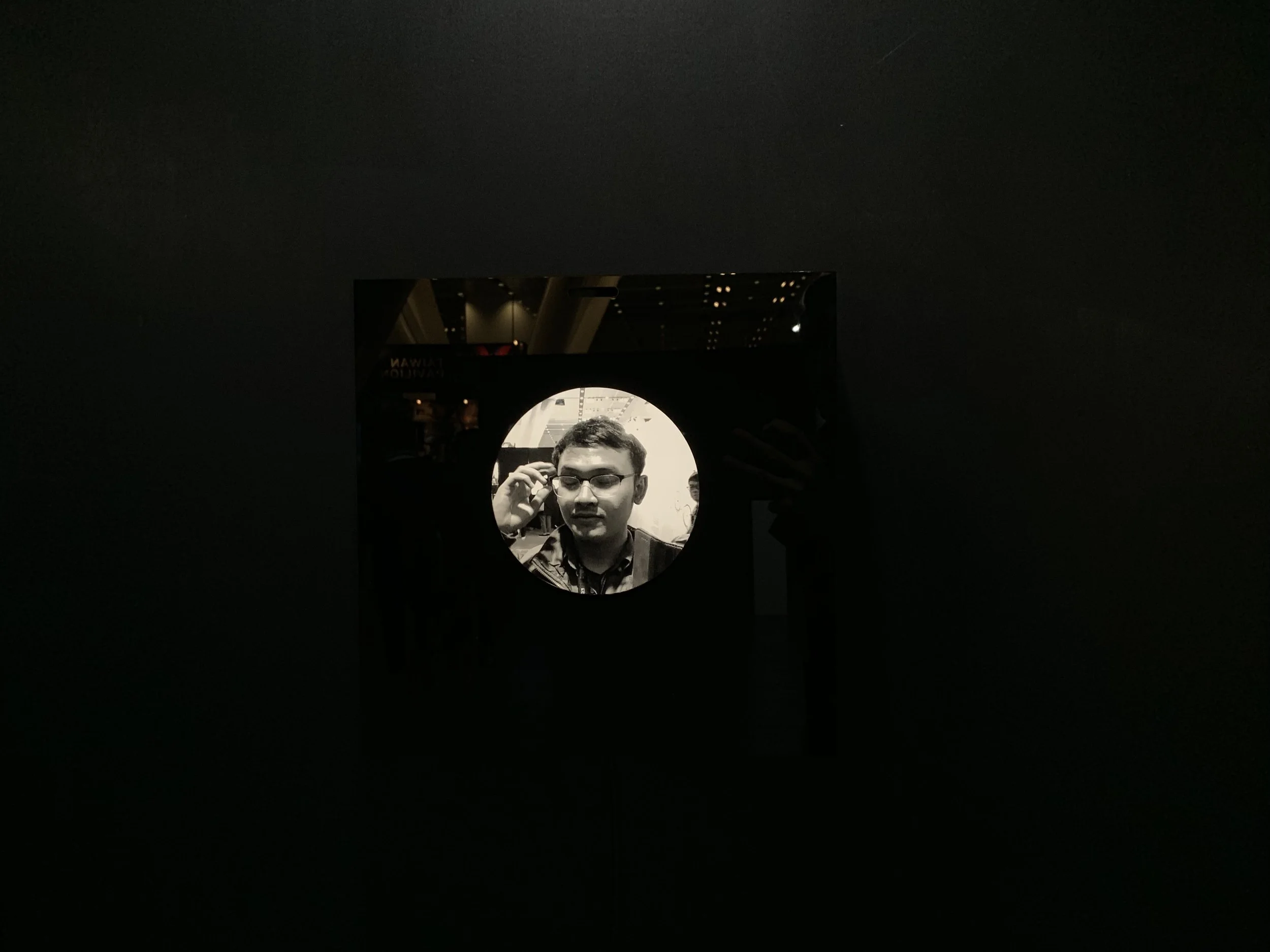 The small circular portrait surrounded by the broad reflective black display.