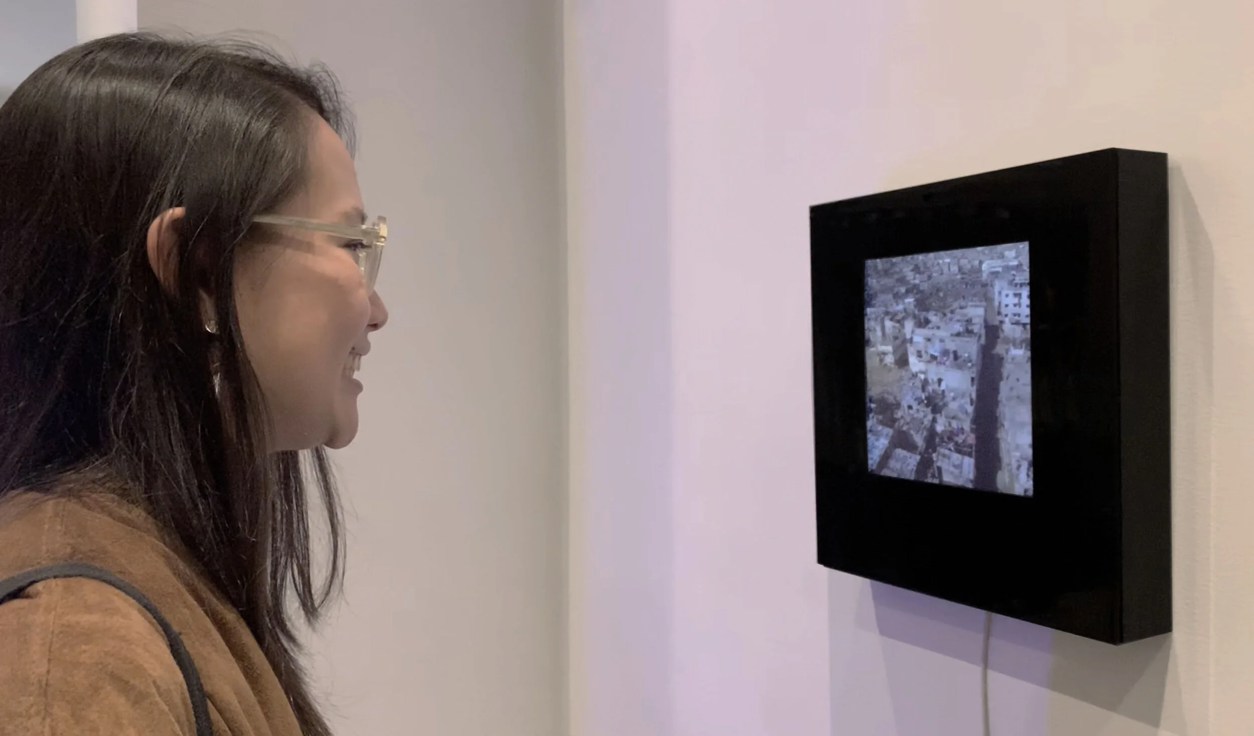 A gallery visitor facing the display of urban imagery in Smile.