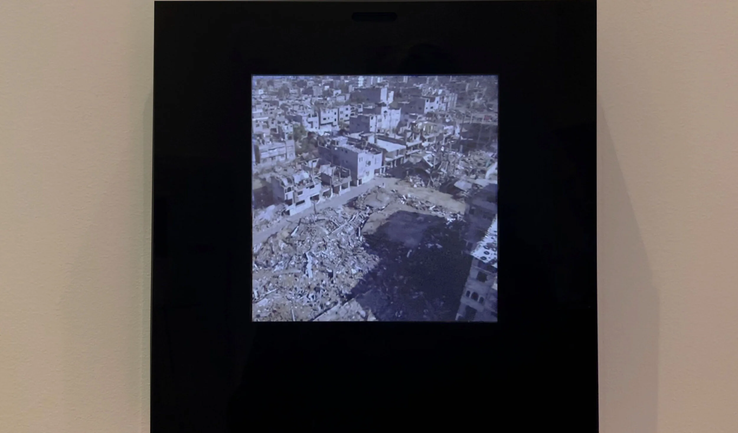 Smile: a wall-mounted black display showing greyscale urban footage.