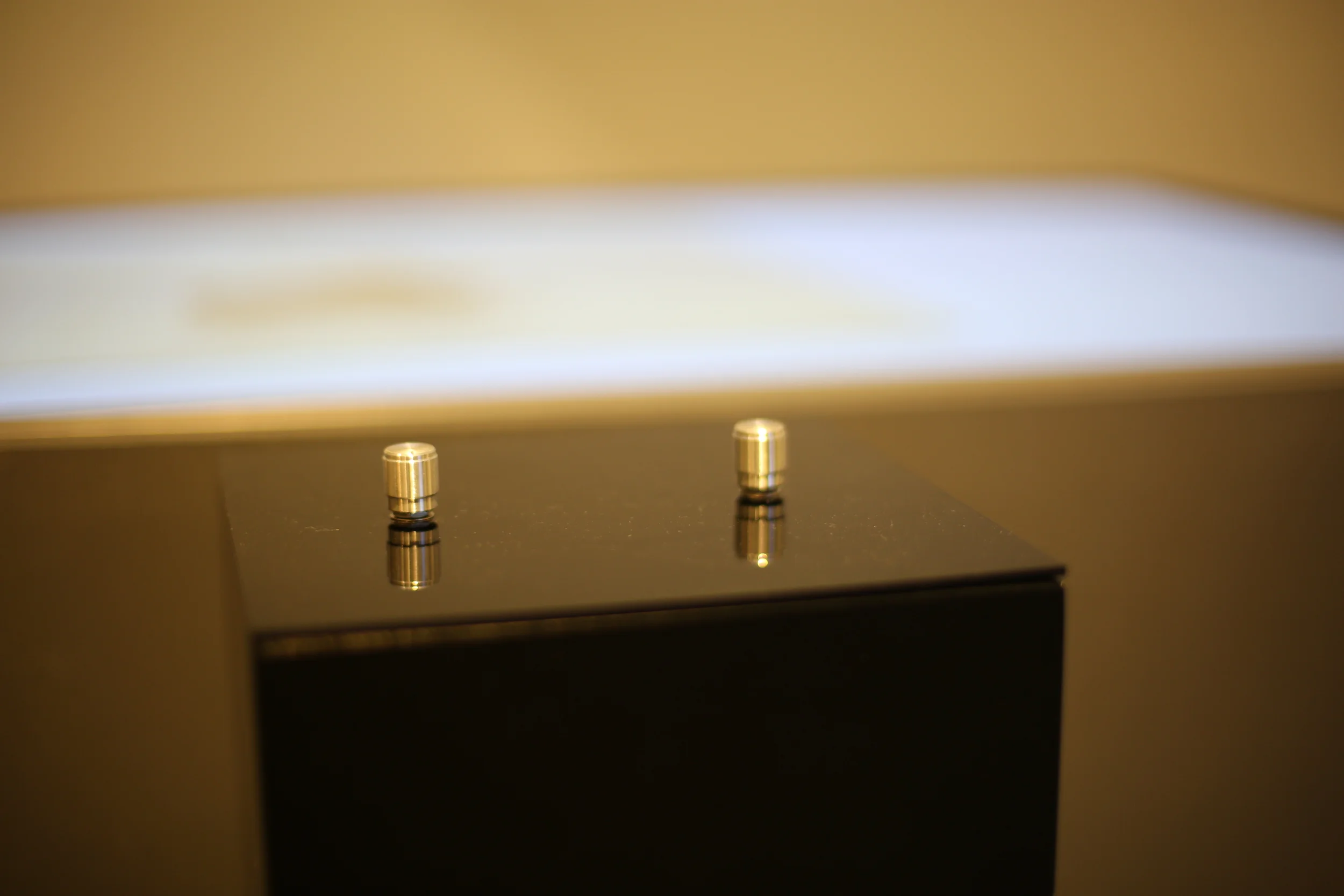 The pair of metallic controls seen against the illuminated table.