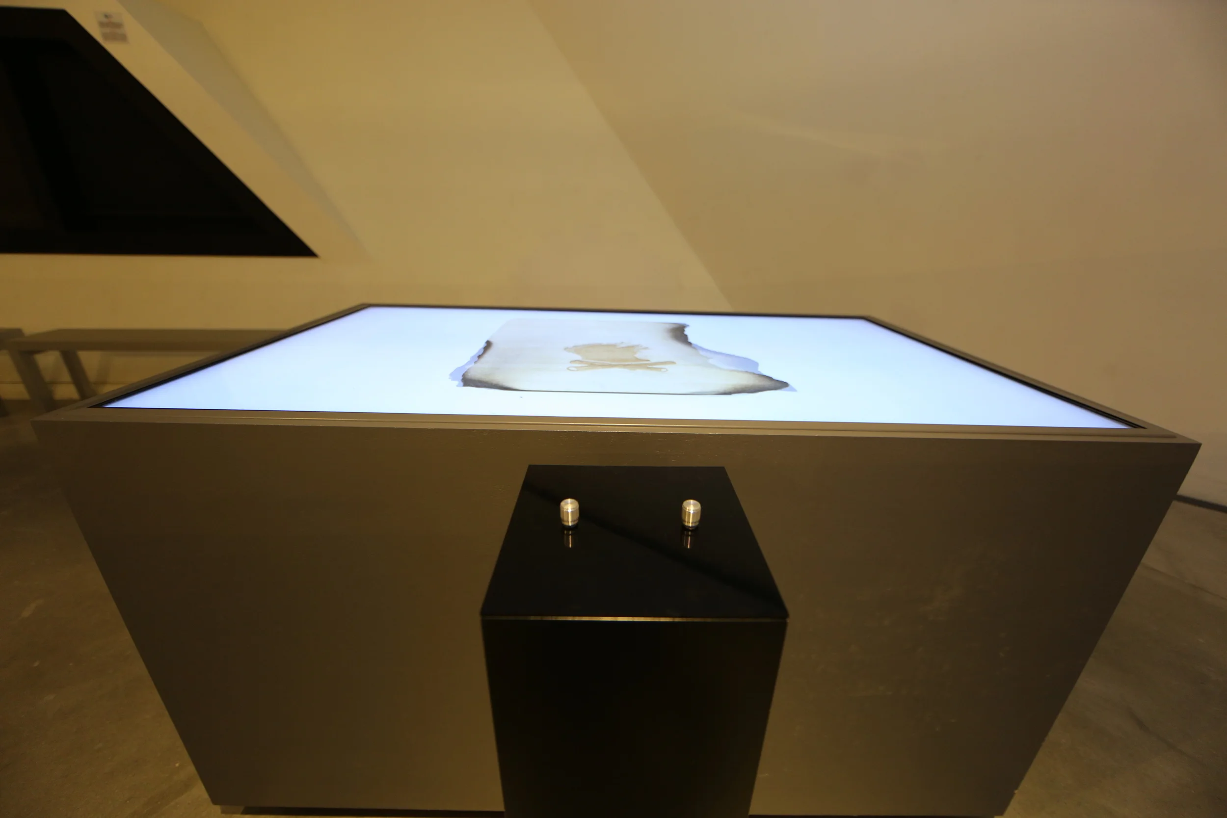 The illuminated tabletop and illustrated parchment above the control pedestal.